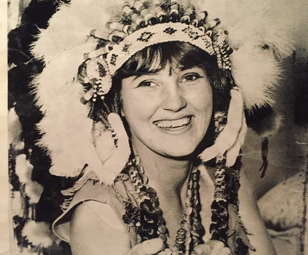 Stylish redhead woman posing in a detailed embroidered denim jacket, showcasing unique fashion.